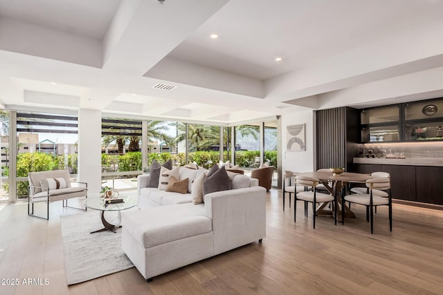 living area featuring healthy amount of natural light, hardwood / wood-style floors, floor to ceiling windows, and recessed lighting