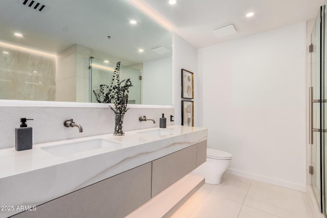 bathroom featuring toilet, a stall shower, tile patterned floors, double vanity, and recessed lighting