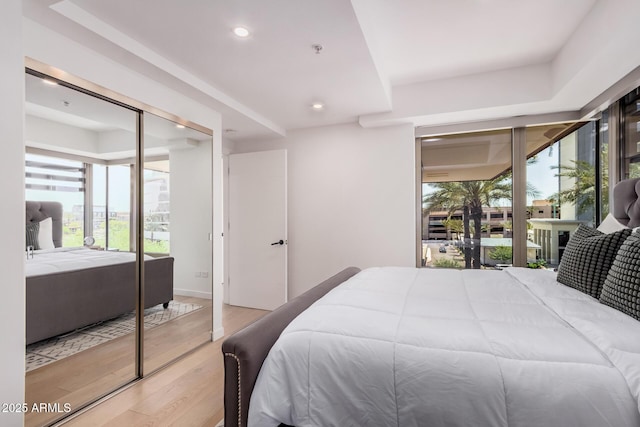 bedroom featuring wood finished floors, multiple windows, and recessed lighting