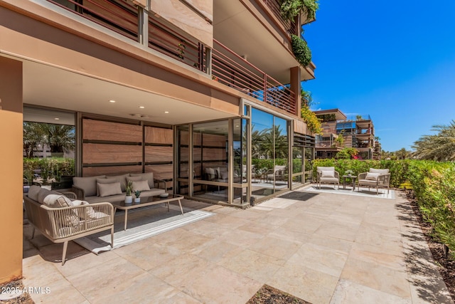 view of patio with an outdoor living space and a balcony