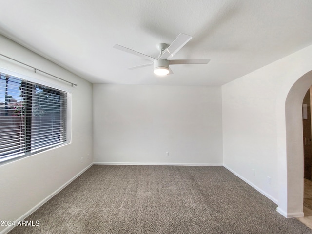 carpeted spare room featuring ceiling fan