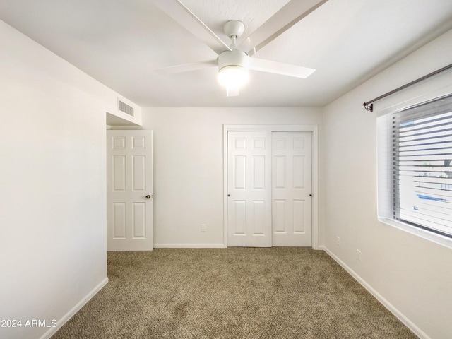 unfurnished bedroom featuring baseboards, visible vents, ceiling fan, carpet flooring, and a closet