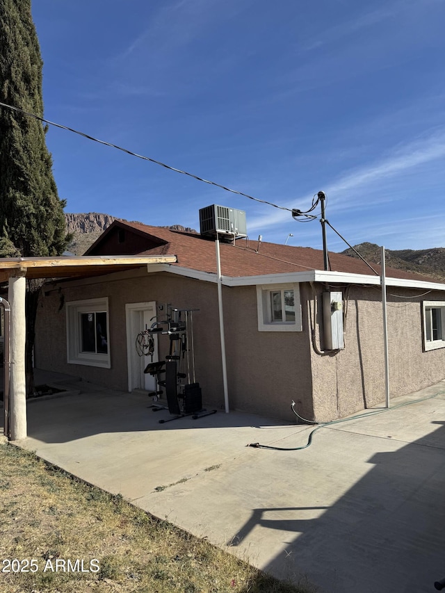 rear view of house with central AC and a patio