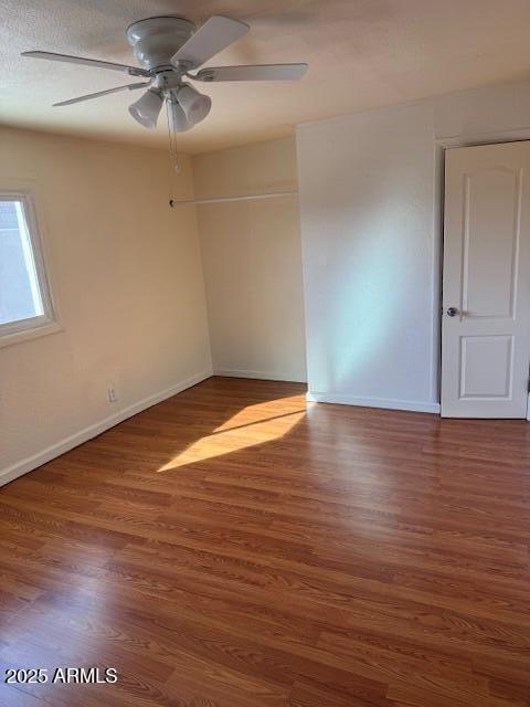 spare room featuring dark wood-type flooring, ceiling fan, and a textured ceiling