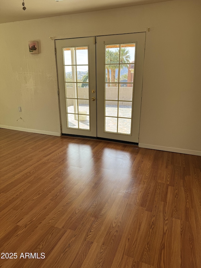 unfurnished room featuring hardwood / wood-style flooring and french doors