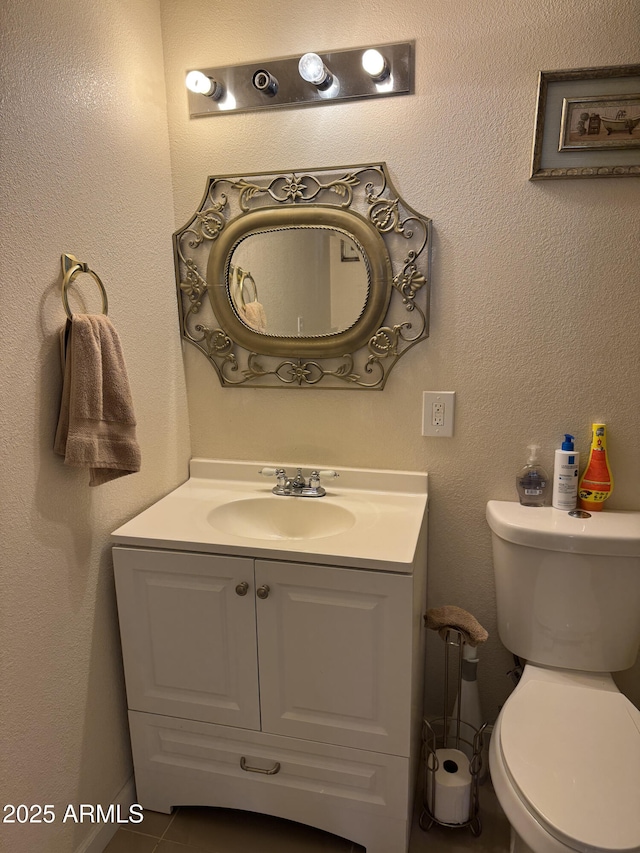 bathroom featuring tile patterned flooring, vanity, and toilet