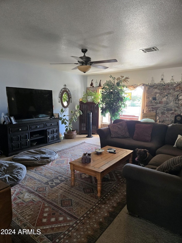 carpeted living room featuring a textured ceiling and ceiling fan