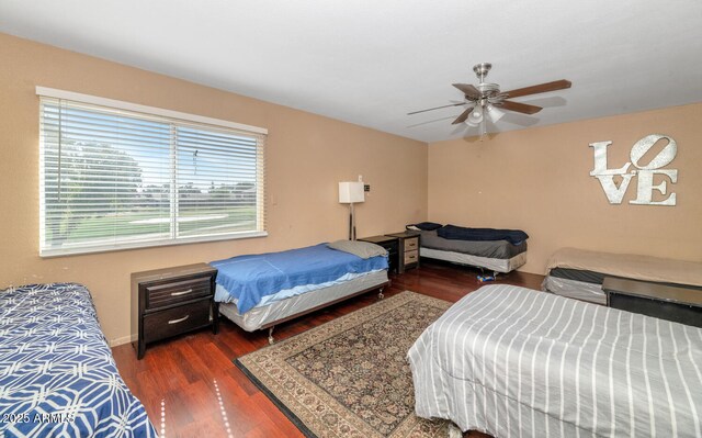 bedroom featuring a ceiling fan, baseboards, and wood finished floors