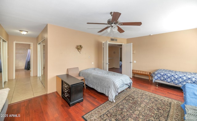 bedroom featuring a ceiling fan, wood finished floors, and visible vents