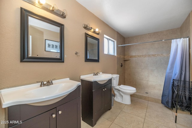 bathroom with a sink, two vanities, a tile shower, and toilet