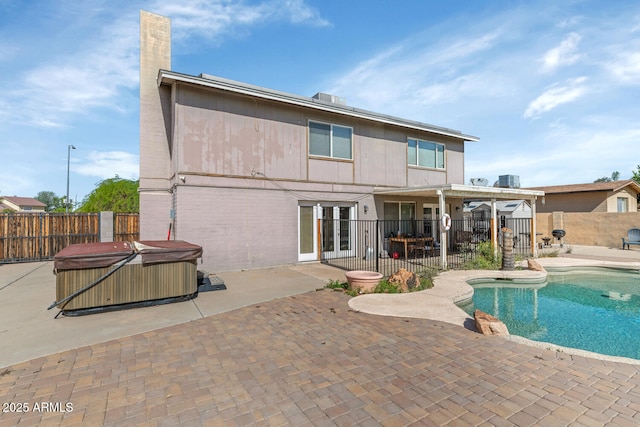 view of swimming pool with a fenced backyard, a hot tub, and a patio area