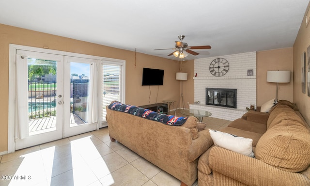 living room featuring french doors, a ceiling fan, light tile patterned floors, and a fireplace
