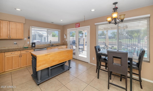 kitchen with wood counters, hanging light fixtures, light tile patterned floors, and light brown cabinets