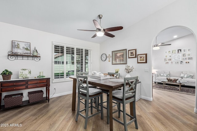 dining area with hardwood / wood-style flooring, ceiling fan, and vaulted ceiling