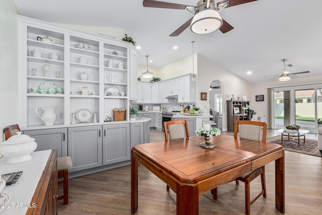 dining room featuring ceiling fan, vaulted ceiling, and light wood-type flooring