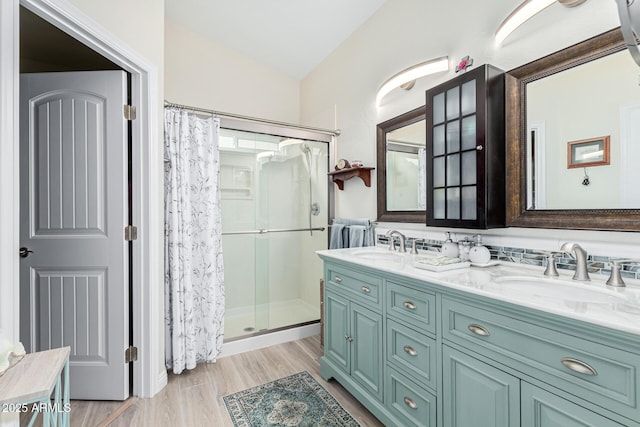 bathroom with walk in shower, vanity, vaulted ceiling, and hardwood / wood-style floors