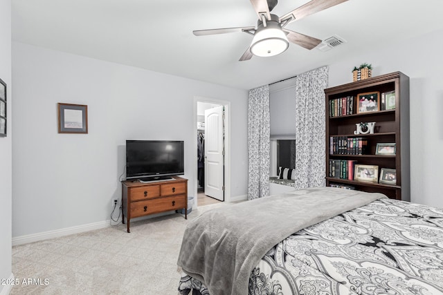 carpeted bedroom with a spacious closet and ceiling fan