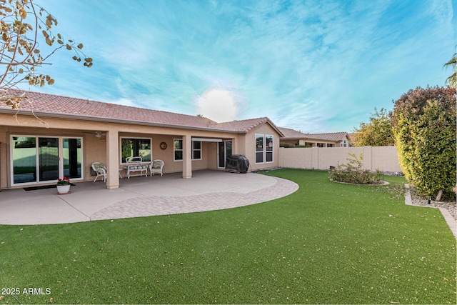 rear view of house with a yard and a patio area