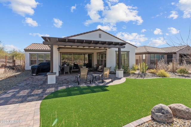 rear view of property featuring a pergola, a patio area, and a lawn