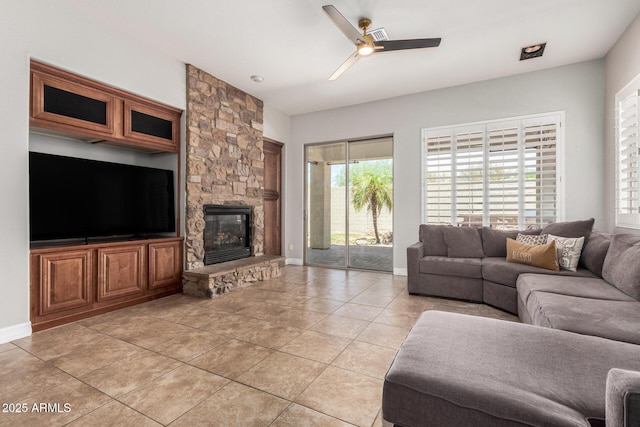 3824 E Parkside Ln, Phoenix, AZ 85050 - living room with ceiling fan, a stone fireplace, light tile patterned floors, and baseboards