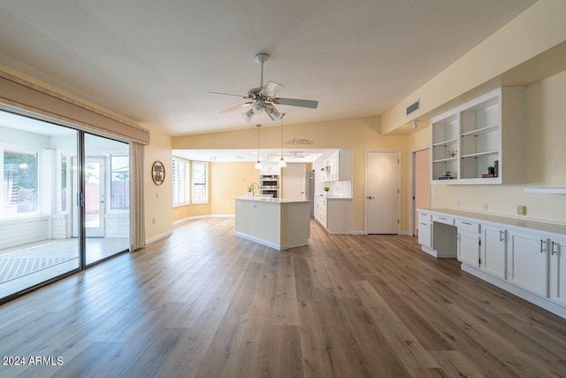 kitchen featuring hardwood / wood-style flooring, lofted ceiling, white cabinetry, hanging light fixtures, and ceiling fan