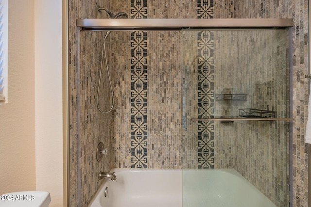 bathroom featuring tiled shower / bath and toilet