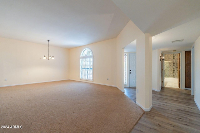 empty room featuring dark hardwood / wood-style flooring and a notable chandelier