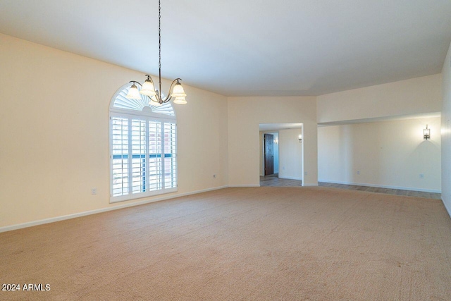 unfurnished room featuring an inviting chandelier and light colored carpet