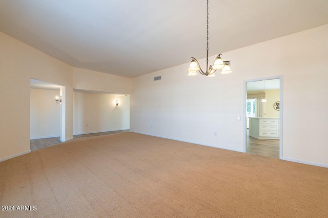 spare room with carpet flooring and a chandelier