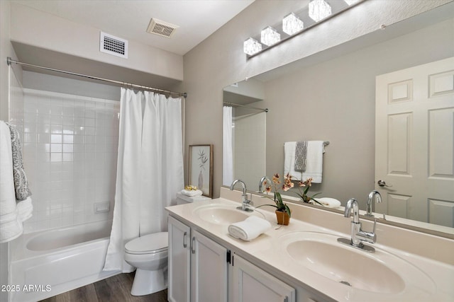 full bathroom featuring vanity, shower / tub combo, hardwood / wood-style flooring, and toilet