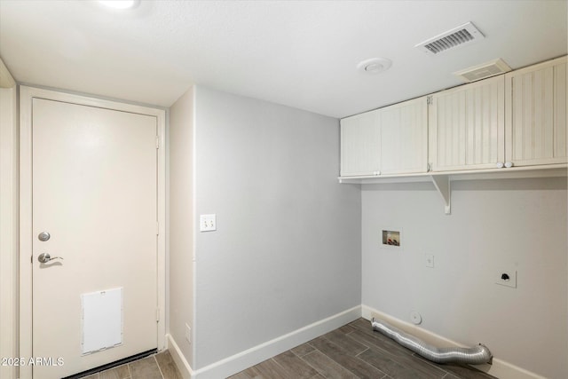 clothes washing area with dark wood-type flooring, hookup for a washing machine, cabinets, hookup for a gas dryer, and hookup for an electric dryer