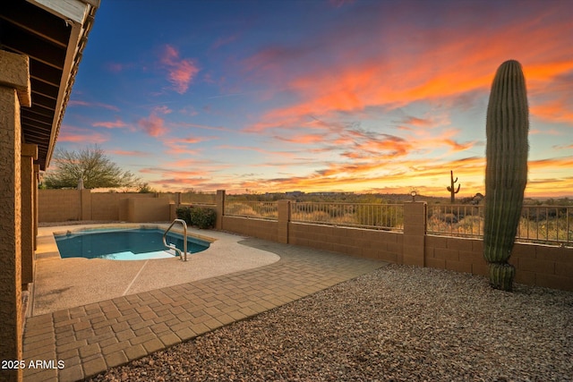 pool at dusk featuring a patio area