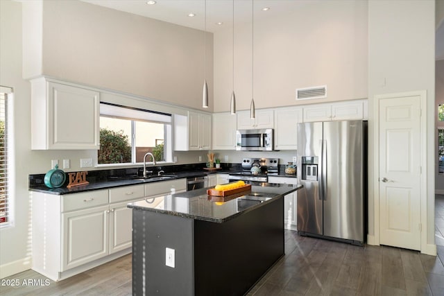 kitchen with sink, decorative light fixtures, a kitchen island, and appliances with stainless steel finishes