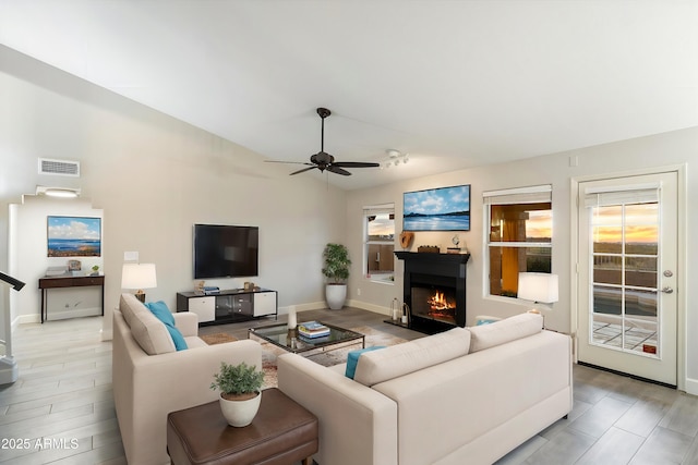 living room featuring wood-type flooring, lofted ceiling, and ceiling fan