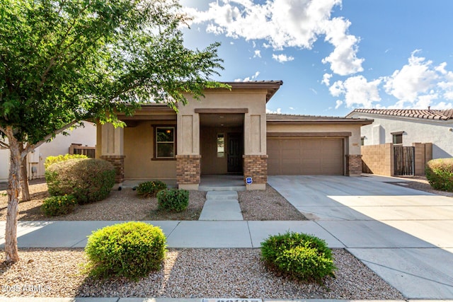 view of front of house featuring a garage, stucco siding, brick siding, a porch, and driveway