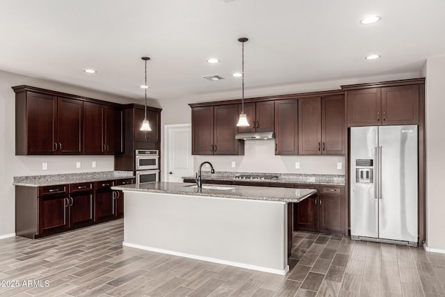 kitchen featuring a sink, under cabinet range hood, wood tiled floor, and stainless steel appliances