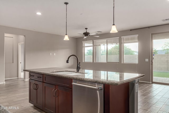 kitchen featuring stainless steel dishwasher, baseboards, a healthy amount of sunlight, and a sink