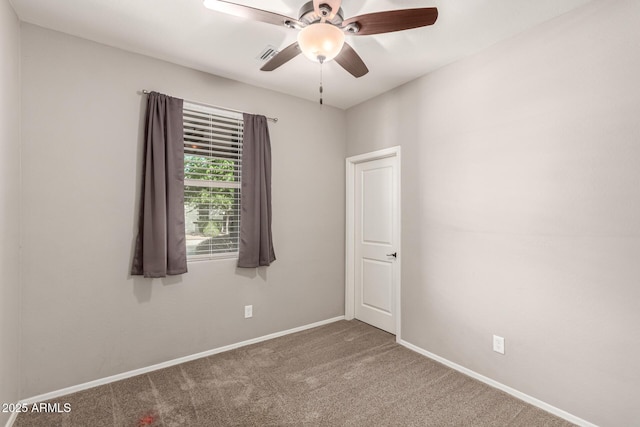 empty room featuring baseboards, carpet flooring, a ceiling fan, and visible vents