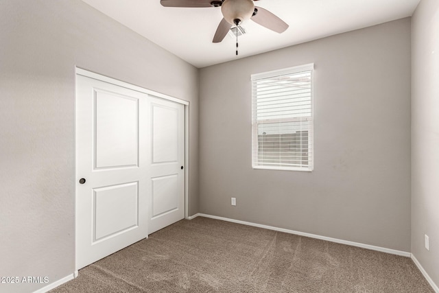 unfurnished bedroom with baseboards, ceiling fan, and carpet