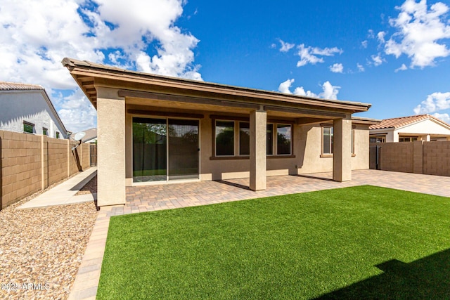 back of property with a fenced backyard, a patio area, and stucco siding
