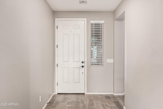 entryway featuring baseboards, wood finished floors, and visible vents