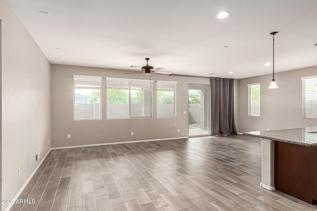 unfurnished living room with baseboards, ceiling fan, recessed lighting, and light wood-style flooring