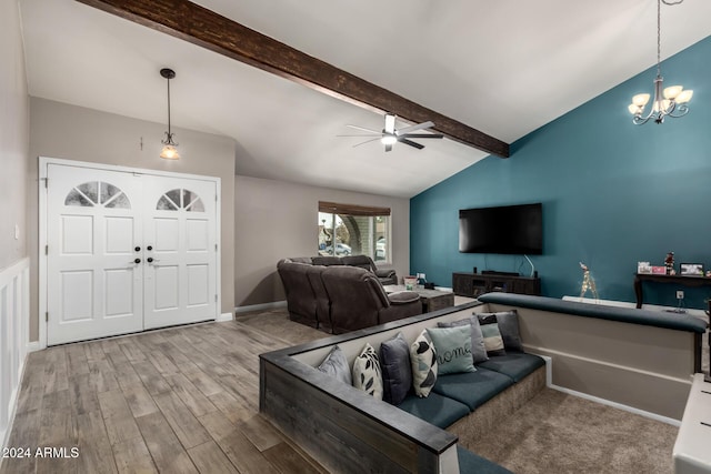 living room with vaulted ceiling with beams, ceiling fan with notable chandelier, and light wood-type flooring