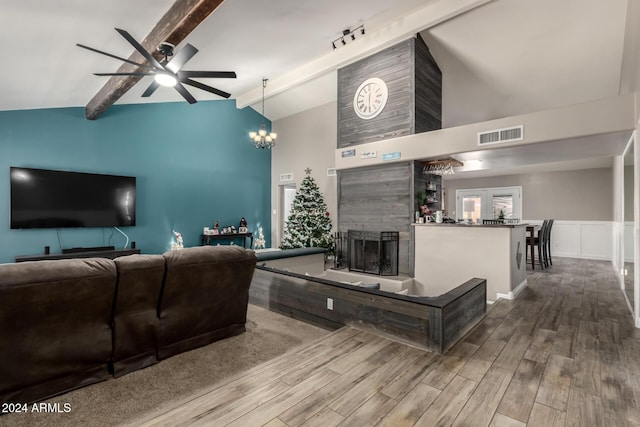 living room featuring ceiling fan with notable chandelier, beam ceiling, hardwood / wood-style flooring, high vaulted ceiling, and a tiled fireplace