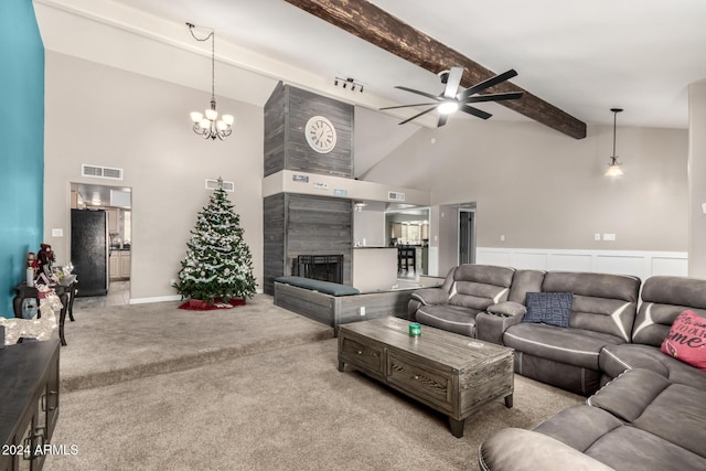 carpeted living room with ceiling fan with notable chandelier, beam ceiling, high vaulted ceiling, and a tiled fireplace