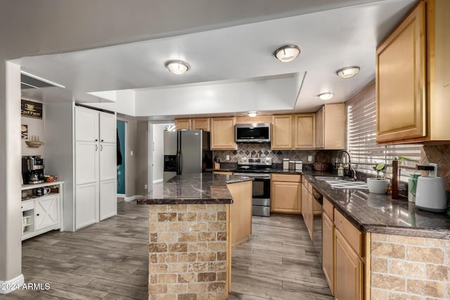 kitchen featuring a center island, light wood-type flooring, sink, and appliances with stainless steel finishes