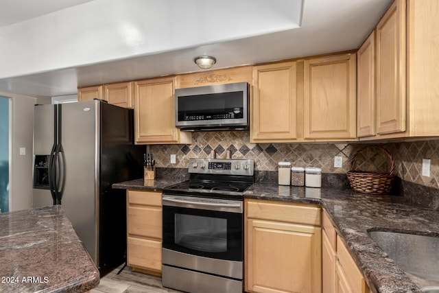 kitchen featuring light brown cabinetry, backsplash, and appliances with stainless steel finishes