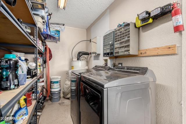 clothes washing area featuring washer and dryer, a textured ceiling, and water heater