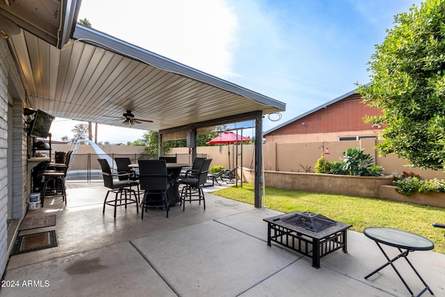 view of patio featuring ceiling fan and a fire pit