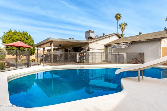 view of pool with ceiling fan, a water slide, and a patio